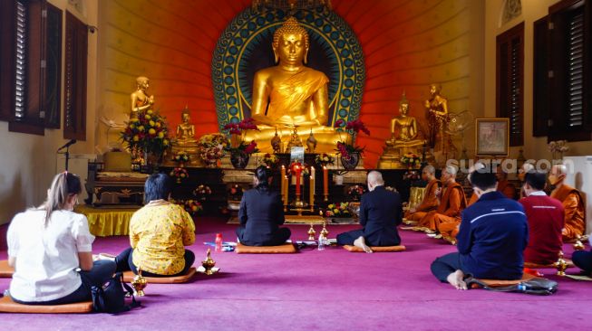 Umat Buddha melakukan ibadah Hari Raya Tri Suci Waisak di Vihara Jakarta Dhammacakka Jaya, Jakarta Utara, Senin (16/5/2022). [Suara.com/Alfian Winanto]