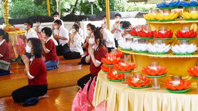 Umat Buddha melakukan ibadah Hari Raya Tri Suci Waisak di Vihara Jakarta Dhammacakka Jaya, Jakarta Utara, Senin (16/5/2022). [Suara.com/Alfian Winanto]