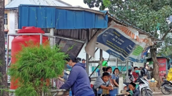 Salah satu warga Batam yang tengah menunggu Bus Trans Batam saat tengah mencuci tangan di Sarana Cuci Tangan Umum Halte Top 100 Jodoh (suara.com/partahi)