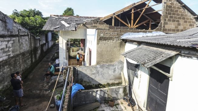 Warga melihat atap rumah yang rusak akibat angin kencang di Bedahan, Depok, Jawa Barat, Senin (16/5/2022). ANTARA FOTO/Asprilla Dwi Adha
