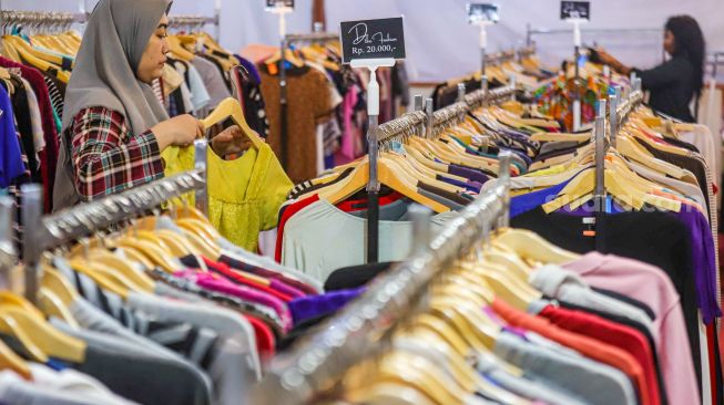 Warga memilih pakaian bekas layak pakai (thrifting) yang dijual di Mal Blok M, Jakarta Selatan, Selasa (17/5/2022). [Suara.com/Alfian Winanto]