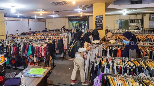 Warga memilih pakaian bekas layak pakai (thrifting) yang dijual di Mal Blok M, Jakarta Selatan, Selasa (17/5/2022). [Suara.com/Alfian Winanto]
