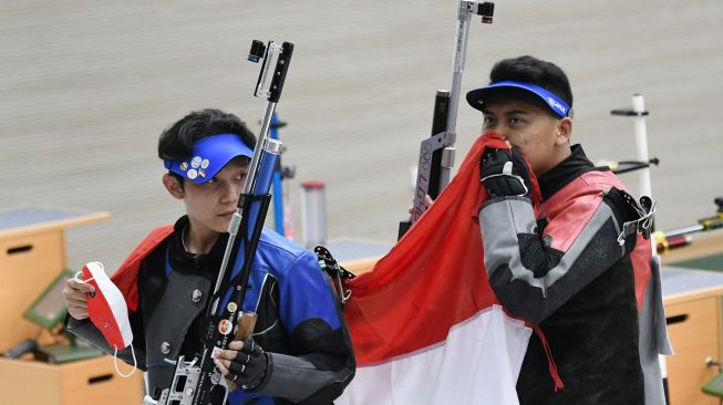 Petembak Fathur Gustafian (kanan) dan rekannya, Paragra Duncan Taruma Negara Sentausa (kiri) mencium bendera Merah Putih usai memenangkan nomor 10 meter air rifle (senapan angin) putra menembak SEA Games 2021 Vietnam di Hanoi Sports Training and Competition Center, Hanoi, Vietnam, Selasa (17/5/2022). ANTARA FOTO/Aditya Pradana Putra