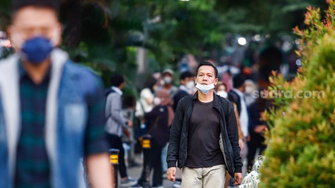 Masyarakat berjalan di pedestrian di kawasan Jalan Thamrin, Jakarta Pusat, Selasa (17/5/2022). [Suara.com/Alfian Winanto]