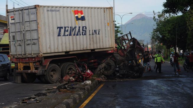 Petugas dibantu warga membersihkan serpihan truk trailer yang mengalami kecelakaan di Jalan Semarang-Solo, Boyolali, Jawa Tengah, Selasa (17/5/2022).  ANTARA FOTO/Aloysius Jarot Nugroho

