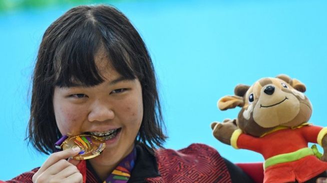 Perenang Indonesia Flairene Candrea Wonomiharjo menggigit medalinya usai upacara pengalungan medali nomor renang 100 meter gaya punggung putri SEA Games 2021 Vietnam di Aquatic Sport Palace, Hanoi, Vietnam, Selasa (17/5/2022). . ANTARA FOTO/Aditya Pradana Putra/rwa. (ANTARA FOTO/ADITYA PRADANA PUTRA)