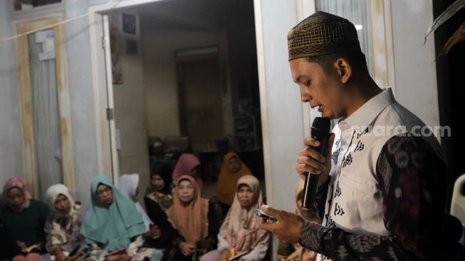 Aktor Kiki Farrel memberikan sambutan kepada warga yang hadir dalam tahlilan 7 hari meninggalnya Mama Dahlia Ramli di kediamannya di kawasan Cireundeu, Ciputat, Kota Tangerang Selatan, Banten, Rabu (18/5/2022). [Suara.com/Angga Budhiyanto]