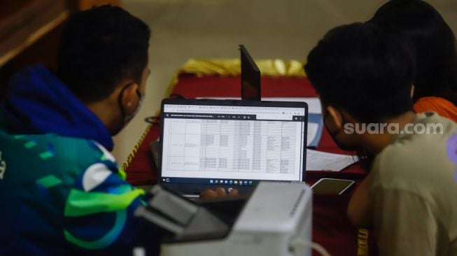 Petugas melayani orang tua calon peserta didik saat Pendaftaran Peserta Didik Baru (PPDB) di Posko Pelayanan PPDB 2022, SMA Negeri 70, Jakarta Selatan, Kamis (19/5/2022). [Suara.com/Alfian Winanto]