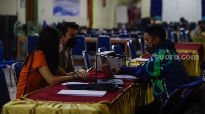 Petugas melayani orang tua calon peserta didik saat Pendaftaran Peserta Didik Baru (PPDB) di Posko Pelayanan PPDB 2022, SMA Negeri 70, Jakarta Selatan, Kamis (19/5/2022). [Suara.com/Alfian Winanto]