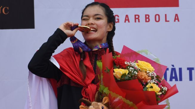 Pesepeda Ayustina Delia Priatna menggigit medalinya usai pengalungan medali nomor individual time trial road cycling SEA Games Vietnam 2021 di Hoa Binh, Vietnam, Jumat (20/5/2022). [ANTARA FOTO/Aditya Pradana Putra/nym]