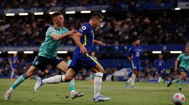 Bek Chelsea Cesar Azpilicueta (tengah) bersaing dengan bek Leicester City Luke Thomas (kiri) saat pertandingan sepak bola Liga Premier Inggris antara Chelsea dan Leicester City di Stadion Stamford Bridge, London, Inggris, Kamis (19/5/2022). [Adrian DENNIS / AFP]
