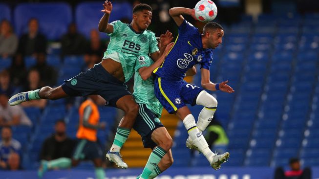 Gelandang Chelsea Hakim Ziyech (kanan) bersaing dengan bek Leicester City Wesley Fofana (kiri) dan Timothy Castagne (tengah) saat pertandingan sepak bola Liga Premier Inggris antara Chelsea dan Leicester City di Stadion Stamford Bridge, London, Inggris, Kamis (19/5/2022). [Adrian DENNIS / AFP]