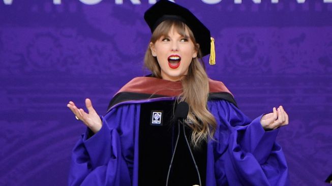 Penyanyi Taylor Swift menyampaikan pidato saat upacara kelulusan New York University angkatan 2022 di Stadion Yankee, New York, Amerika Serikat, Rabu (18/5/2022). [Angela Weiss / AFP]
