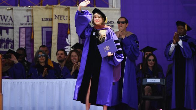 Penyanyi Taylor Swift menerima gelar doktor kehormatan seni rupa saat upacara kelulusan New York University angkatan 2022 di Stadion Yankee, New York, Amerika Serikat, Rabu (18/5/2022). [Angela Weiss / AFP]
