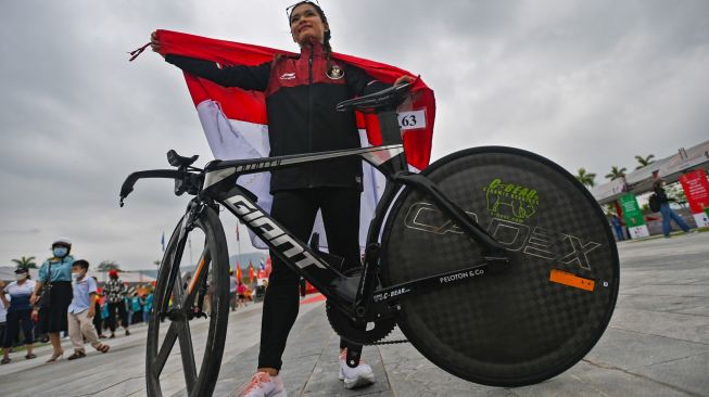 Pesepeda Ayustina Delia Priatna berpose dengan bendera Merah Putih usai memenangi nomor individual time trial road cycling SEA Games Vietnam 2021 di Hoa Binh, Vietnam, Jumat (20/5/2022). [ANTARA FOTO/Aditya Pradana Putra/nym]