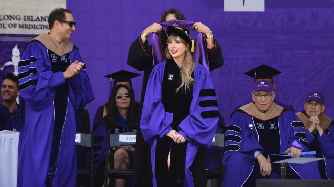 Penyanyi Taylor Swift menerima gelar doktor kehormatan seni rupa saat upacara kelulusan New York University angkatan 2022 di Stadion Yankee, New York, Amerika Serikat, Rabu (18/5/2022). [Angela Weiss / AFP]
