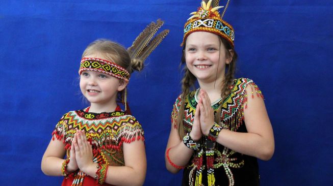 Dua anak Warga Negara Asing asal Amerika berpose saat berfoto di studio saat acara pembukaan Pekan Gawai Dayak ke-36 di Rumah Radakng, Pontianak, Kalimantan Barat, Jumat (20/5/2022). [ANTARA FOTO/Jessica Helena Wuysang/foc]