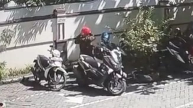 Potongan video aksi pria mengendarai sepeda motor dinas mencuri helm di Pengadilan Agama Brebes. [Facebook/PEMALI BREBES]