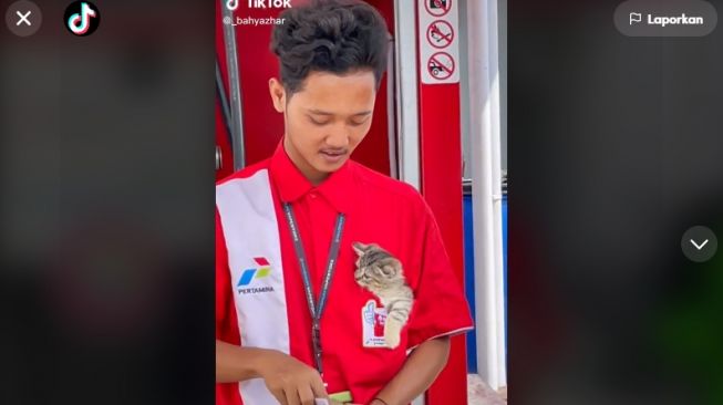 Gemes Banget! Viral Pegawai SPBU Momong Kucing Dalam Saku Sambil Bekerja, Netizen: Pake Penglaris Ya