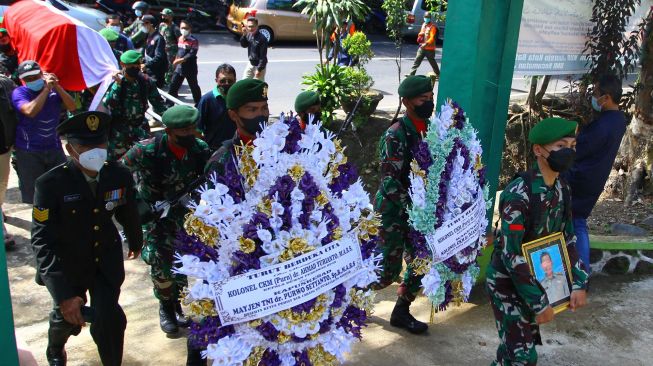 Anggota TNI dari Yonkes 2/Divif 2 Kostrad memanggul peti berisi jenazah almarhum Achmad Yurianto untuk dimakamkan di pemakaman umum Dadaprejo, Batu, Jawa Timur, Minggu (22/5/2022). ANTARA FOTO/Ari Bowo Sucipto