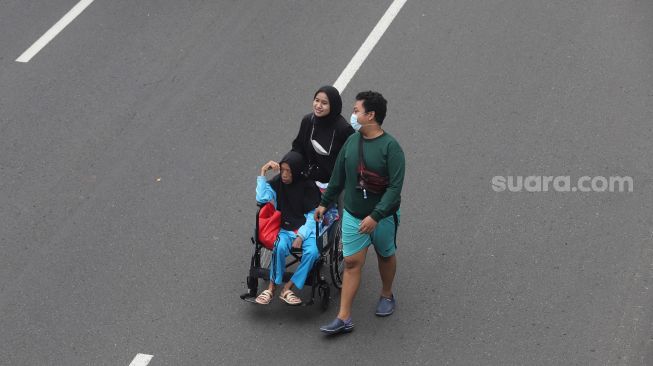 Warga berolahraga di area 'car free day' (CFD) di Jalan Jenderal Sudirman, Jakarta, Minggu (22/5/2022). [Suara.com/Angga Budhiyanto]