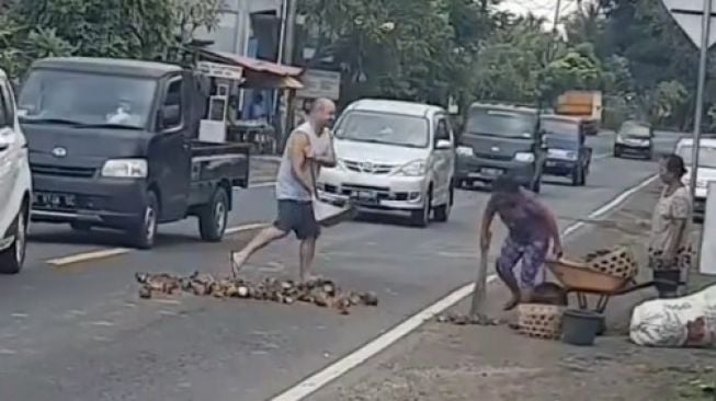 Aksi Bule Ini Jadi Sorotan Warganet, Turun dari Mobil Kumpulkan Kulit Kelapa di Jalan Raya