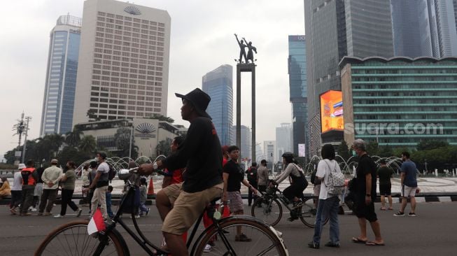 Warga berolahraga di area 'car free day' (CFD) di kawasan Bundaran Hotel Indonesia, Jakarta, Minggu (22/5/2022). [Suara.com/Angga Budhiyanto]