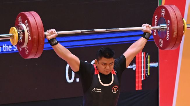 Lifter Indonesia Muhammad Zul Ilmi melakukan angkatan snatch dalam pertandingan nomor 89 kilogram angkat berat SEA Games 2021 Vietnam di Hanoi Sports Training Centre, Hanoi, Vietnam, Minggu (22/5/2022). ANTARA FOTO/Aditya Pradana Putra