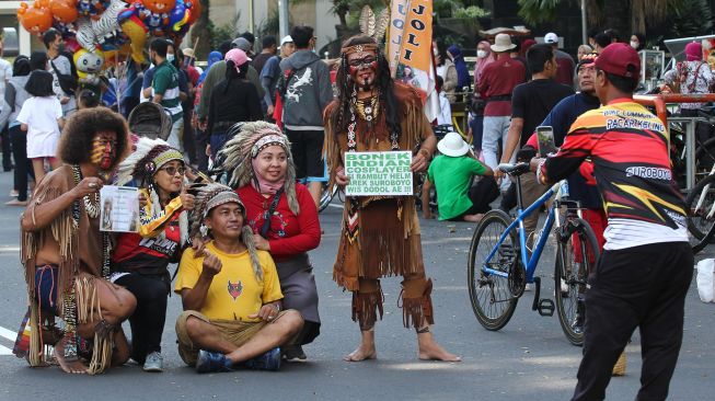 Warga berfoto bersama saat Hari Bebas Kendaraan Bermotor atau Car Free Day (CFD) di Jalan Darmo, Surabaya, Jawa Timur, Minggu (22/5/2022). ANTARA FOTO/Didik Suhartono

