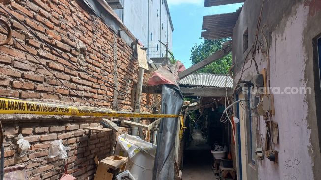 Tembok gudang kosong yang roboh telah diberi garis polisi setelah menimpa empat orang Kapuk Cengkareng, Jakarta Barat, Senin (23/5/2022). [Suara.com/Faqih Fathurrahman]