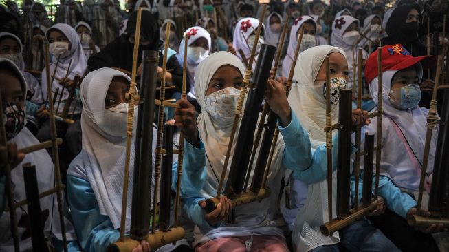 Wisatawan mengikuti pertunjukan angklung di Saung Angklung Udjo, Bandung, Jawa Barat, Senin (23/5/2022). ANTARA FOTO/Raisan Al Farisi
