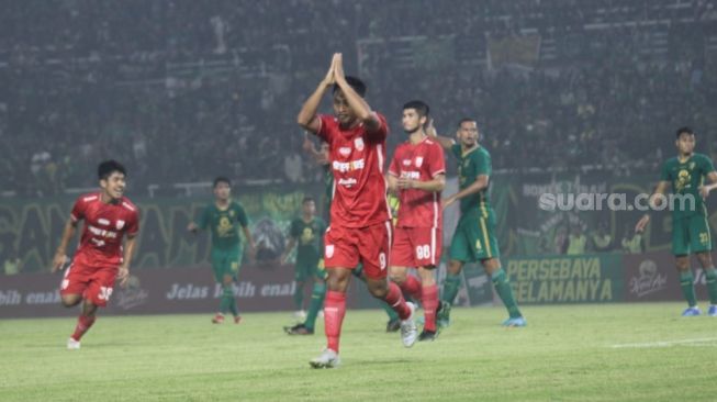 Striker Persis Solo, Samsul Arif mengeluarkan gestur minta maaf usai mencetak gol ke gawang Persebaya Surabaya di Stadion Gelora Bung Tomo, Minggu (22/5/2022). [Suara.com/Ronald Seger Prabowo]