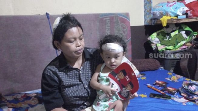 Sri (39) dan balitanya yang masih berusia 2 tahun menjadi korban tembok roboh di Kapuk, Cengkareng, Jakarta Barat, Senin (23/5/2022). [Suara.com/Faqih Fathurrahman]