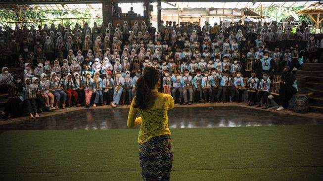 Wisatawan mengikuti pertunjukan angklung di Saung Angklung Udjo, Bandung, Jawa Barat, Senin (23/5/2022). ANTARA FOTO/Raisan Al Farisi
