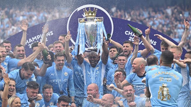 Para pemain Manchester City mengangkat trofi Juara Liga Inggris usai pertandingan sepak bola Liga Utama Inggris antara Manchester City dan Aston Villa di Stadion Etihad di Manchester, Inggris, pada 22 Mei 2022.  [Oli Scarf / AFP]