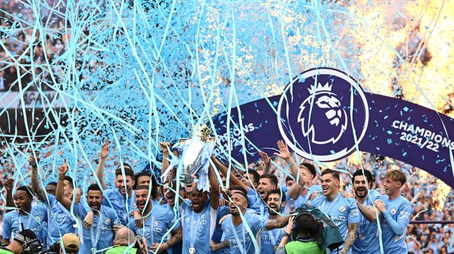 Para pemain Manchester City mengangkat trofi Juara Liga Inggris usai pertandingan sepak bola Liga Utama Inggris antara Manchester City dan Aston Villa di Stadion Etihad di Manchester, Inggris, pada 22 Mei 2022.  [Oli Scarf / AFP]