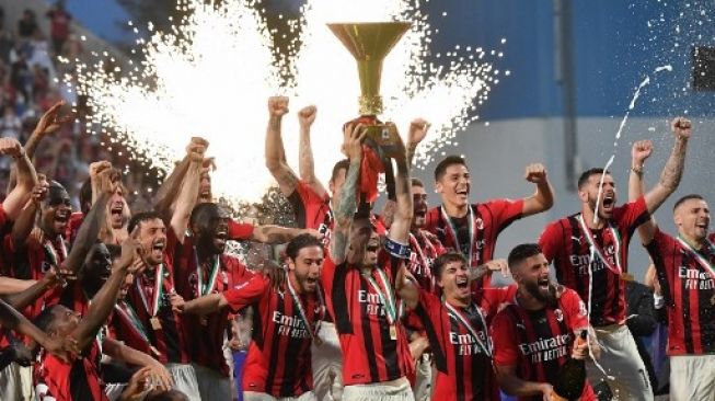 Bek AC Milan Italia Alessio Romagnoli (tengah) dan para pemain AC Milan mengangkat trofi juara Liga Italia setelah AC Milan memenangkan pertandingan sepak bola Serie A Italia antara Sassuolo dan AC Milan, mengamankan gelar "Scudetto" pada 22 Mei 2022 di Mapei - Citta Stadion del Tricolore di Sassuolo.Tiziana FABI / AFP
