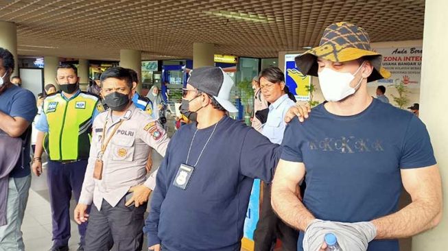 Pelaku WN Bulgaria berinisial VTL salah satu pelaku skimming Bank Riau Kepri saat tiba di Bandara Hang Nadim Batam. [Suara.com/Partahi]