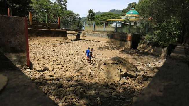 Sejumlah anak bermain di objek wisata pemandian Mata Ie yang kering di Desa Geundring, Darul Imarah, Aceh Besar, Aceh, Selasa (24/5/2022).  ANTARA FOTO/Syifa Yulinnas