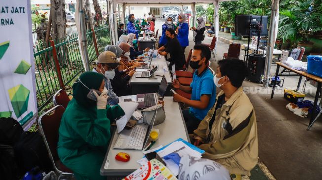 Sejumlah warga mengikuti pemeriksaan kesehatan di Pasar Induk Kramat Jati, Jakarta Timur, Selasa (24/5/2022). [Suara.com/Alfian Winanto]