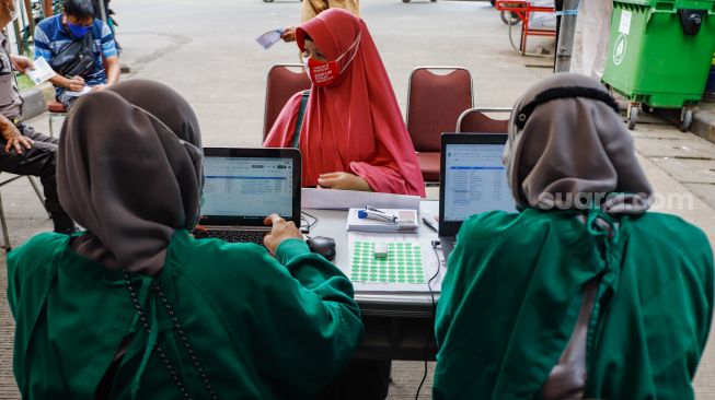 Warga mengikuti pemeriksaan kesehatan di Pasar Induk Kramat Jati, Jakarta Timur, Selasa (24/5/2022). [Suara.com/Alfian Winanto]