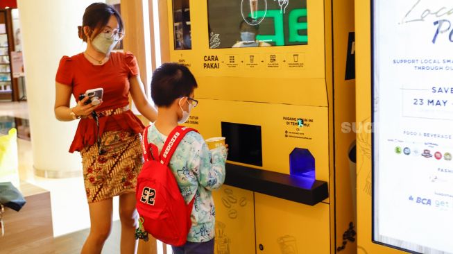 Calon pembeli berbelanja menggunakan vending machine di Grand Indonesia, Jakarta Pusat, Selasa (24/5/2022). [Suara.com/Alfian Winanto]