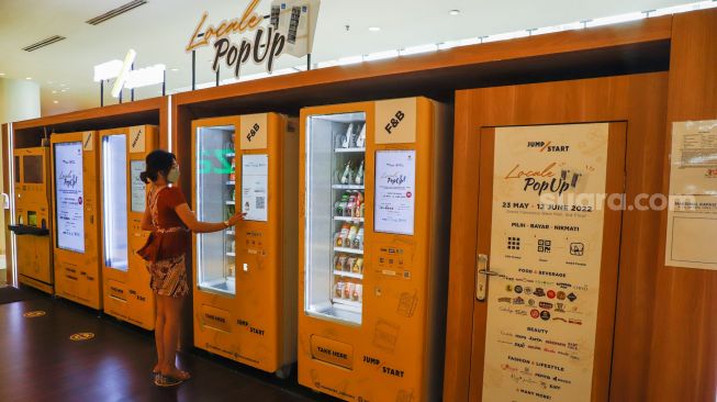 Calon pembeli berbelanja menggunakan vending machine di Grand Indonesia, Jakarta Pusat, Selasa (24/5/2022). [Suara.com/Alfian Winanto]