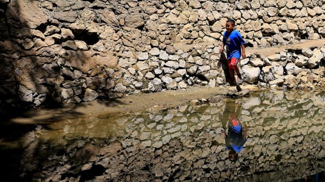 Sejumlah anak bermain di objek wisata pemandian Mata Ie yang kering di Desa Geundring, Darul Imarah, Aceh Besar, Aceh, Selasa (24/5/2022).  ANTARA FOTO/Syifa Yulinnas