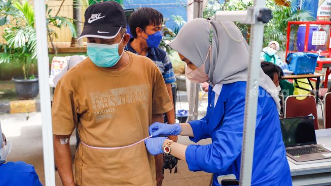 Warga mengikuti pemeriksaan kesehatan di Pasar Induk Kramat Jati, Jakarta Timur, Selasa (24/5/2022). [Suara.com/Alfian Winanto]