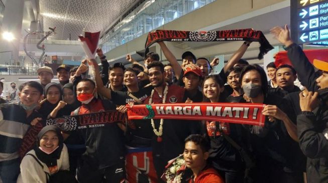 Suporter mengabadikan momen kedatangan timnas Indonesia U-23 di Bandara Soekarno-Hatta, Tangerang, Banten Senin (23/5/2022) dengan berfoto bersama. (ANTARA/Muhammad Ramdan)