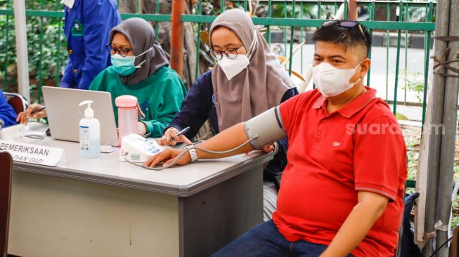 Warga mengikuti pemeriksaan kesehatan di Pasar Induk Kramat Jati, Jakarta Timur, Selasa (24/5/2022). [Suara.com/Alfian Winanto]