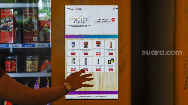 Calon pembeli berbelanja menggunakan vending machine di Grand Indonesia, Jakarta Pusat, Selasa (24/5/2022). [Suara.com/Alfian Winanto]