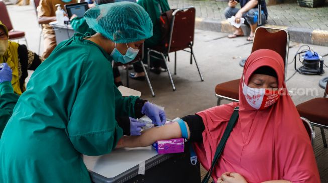 Warga mengikuti pemeriksaan kesehatan di Pasar Induk Kramat Jati, Jakarta Timur, Selasa (24/5/2022). [Suara.com/Alfian Winanto]