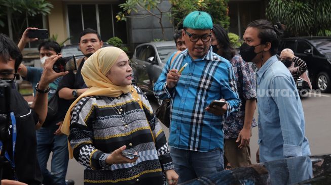 Presenter Uya Kuya didampingi istrinya, Astrid Khairunisha tiba untuk menjalani pemeriksaan di Polda Metro Jaya, Jakarta, Rabu (25/5/2022). [Suara.com/Angga Budhiyanto]